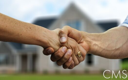 Agente inmobiliario estrechando la mano con un cliente.